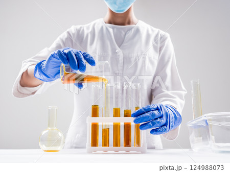 Scientist pouring organic oil. Beauty and cosmetics sciences. Scientist pouring organic oil. Beauty and cosmetics sciences. 124988073