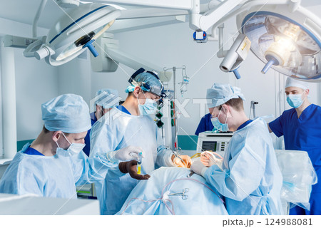 Spinal surgery. Group of surgeons in operating room with surgery equipment.  124988081