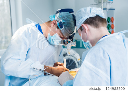 Spinal surgery. Group of surgeons in operating room with surgery equipment.  124988200
