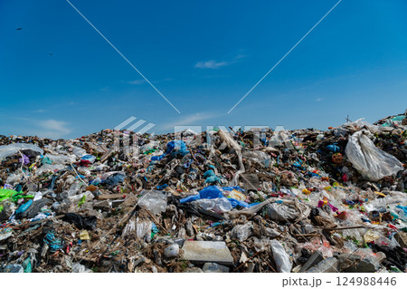 A vast landfill site accumulates trash consisting of plastic, debris, and various waste materials, highlighting urban pollution issues 124988446