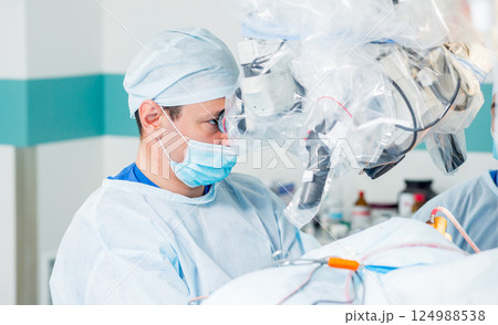Brain surgery. Group of surgeons in operating room with surgery equipment. 124988538