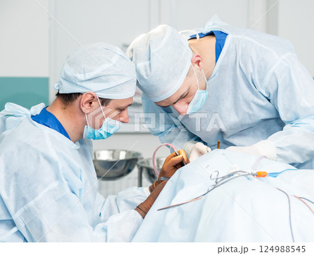 Brain surgery. Group of surgeons in operating room with surgery equipment. Brain surgery. Group of surgeons in operating room with surgery equipment. 124988545