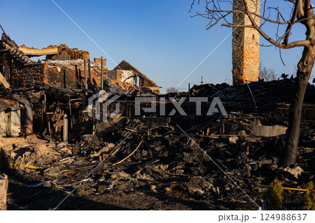 Ruins of a burned building reveal charred remains and debris, illustrating the impact of a recent fire in a rural setting during daylight Ruins of a burned building reveal charred remains and debris, illustrating the impact of a recent fire in a rural setting during daylight 124988637