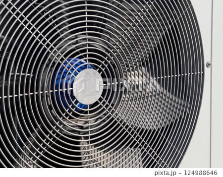 An industrial fan is set up outdoors, efficiently circulating air in a warm environment, ensuring comfort and cooling An industrial fan is set up outdoors, efficiently circulating air in a warm environment, ensuring comfort and cooling 124988646