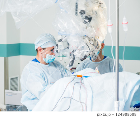 Brain surgery. Group of surgeons in operating room with surgery equipment. 124988689