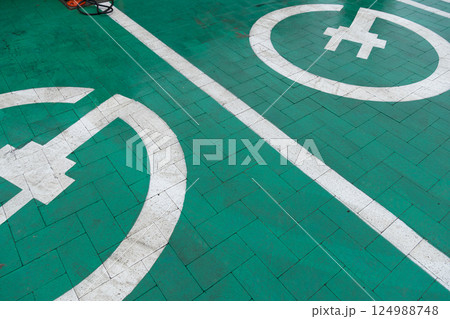 Clear markings on a green parking area designate spaces for electric vehicles and bicycles, promoting eco-friendly transportation options 124988748