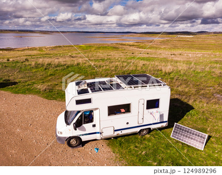 Caravan solar panels on roof camping on lake shore. Aerial view 124989296