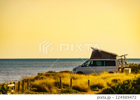 Camper van with roof top tent camp on beach 124989472