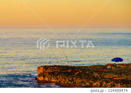 Fishing poles at sea shore. 124989474