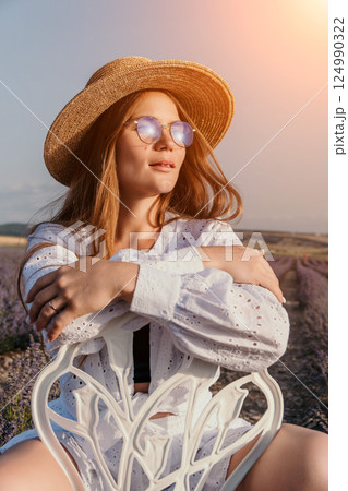 Woman Lavender Field Summer Fashion: Relaxed pose, outdoor summer fashion photoshoot in a lavender field, showcasing a straw hat, white shirt, and blue-light glasses. Woman Lavender Field Summer Fashion: Relaxed pose, outdoor summer fashion photoshoot in a lavender field, showcasing a straw hat, white shirt, and blue-light glasses. 124990322