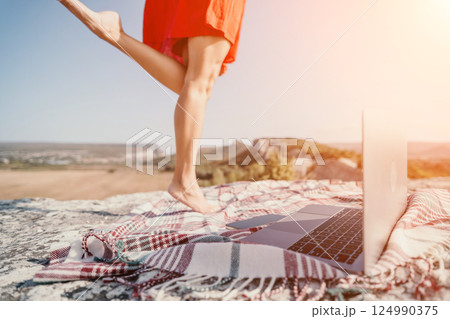 Laptop on a Plaid Blanket with Woman's Legs in the Background Laptop on a Plaid Blanket with Woman's Legs in the Background 124990375