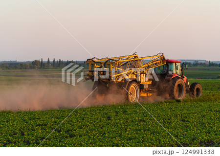 Tractor working on the farm at sunset. Tractor on the field. Farm machinery. Special equipment, agriculture Tractor working on the farm at sunset. Tractor on the field. Farm machinery. Special equipment, agriculture 124991338