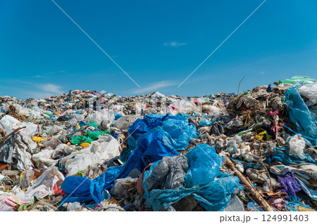 A pile of garbage in a landfill against a blue sky. Plastic scrap in landfill. Concept of ecology 124991403