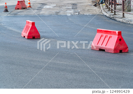New asphalt road. Plastic road fencing New asphalt road. Plastic road fencing 124991429