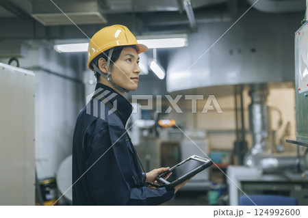 タブレットを持った作業服を着た30代の男性 124992600