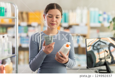 Woman choosing between lotion and cream in pharmacy Woman choosing between lotion and cream in pharmacy 124992837