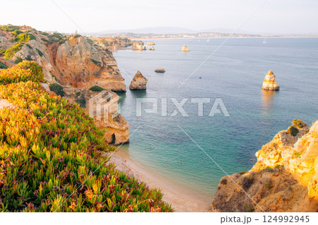 Scenic Algarve coastline: Cliffs, beach, and turquoise water attract tourists for relaxation 124992945