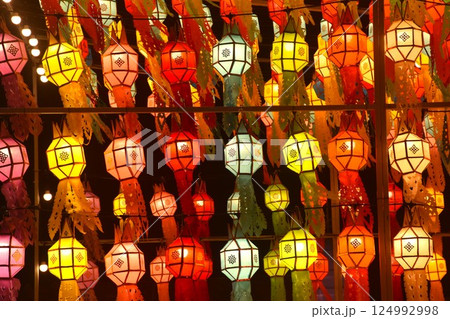 colorful paper Eastern Thai lantern style with electric lamp hanging on wall in night 124992998