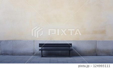 Minimalistic image of a black wooden bench against a stone beige wall with a metal frame. Surrounding by light grey elements, the composition exudes peace and tranquility 124993111