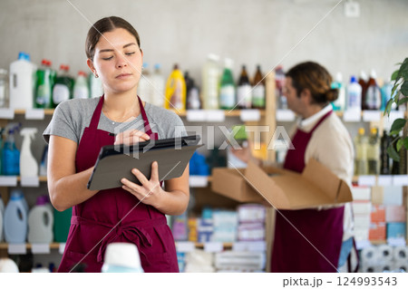 Female store supervisor taking inventory of cleaning and hygiene products using tablet 124993543