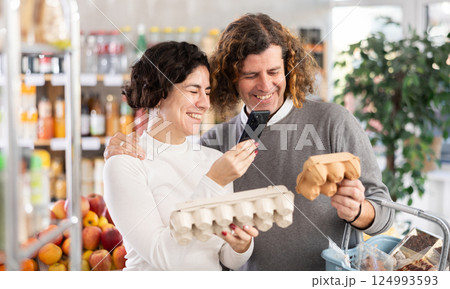 Woman and man scanning eggs in store Woman and man scanning eggs in store 124993593
