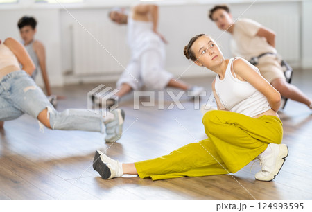 Group of young friends learn group dances - low break and breakdance in studio Group of young friends learn group dances - low break and breakdance in studio 124993595