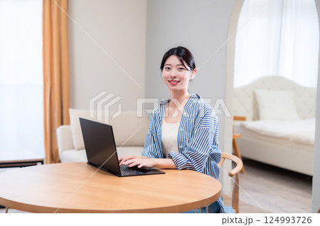 自宅で笑顔でリモート会議に参加する若い女性 自宅で笑顔でリモート会議に参加する若い女性 124993726