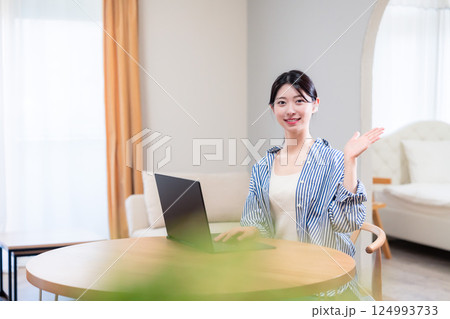 自宅で笑顔でリモート会議に参加する若い女性 124993733
