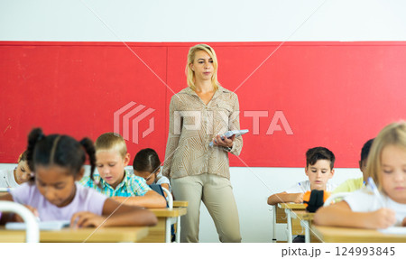 Female teacher giving lesson with tweens in primary school 124993845