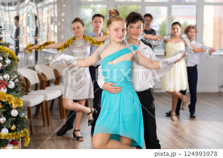 Teen boy and girl dancing waltz in couple during lesson at studio in New Year atmosphere 124993978