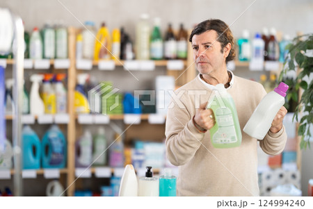 Man consumer with household chemical products for washing indoors 124994240