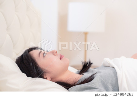 ベッドで寝る若い女性 124994263