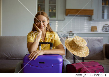 Young woman wearing straw summer hat with travel luggage 124994301