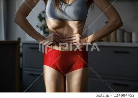 Midsection shot of woman sunken belly and anorexic skinny body 124994452