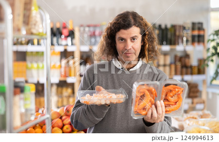 man chooses different shrimps 124994613