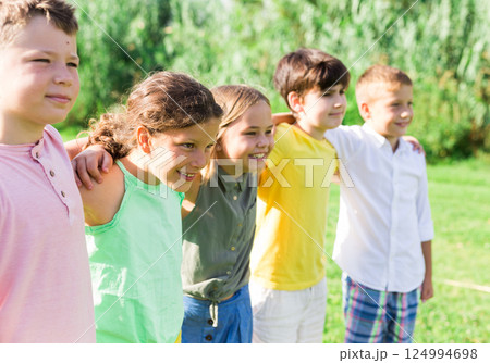 Portrait of five smiling friends kids posing in a park 124994698