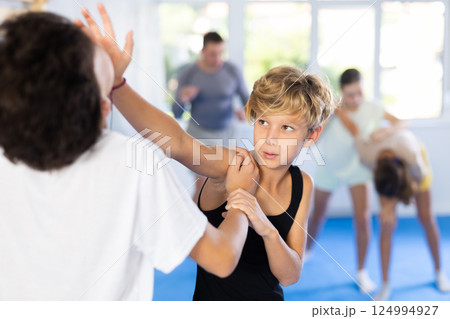 Boy and girl train to perform works out blow to jaw at opponent, while learning self-defense Boy and girl train to perform works out blow to jaw at opponent, while learning self-defense 124994927