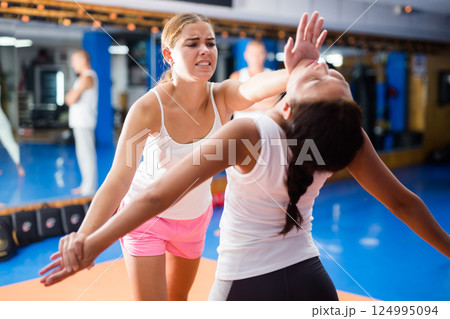 Two women mastering palm heel strike in self defence training Two women mastering palm heel strike in self defence training 124995094