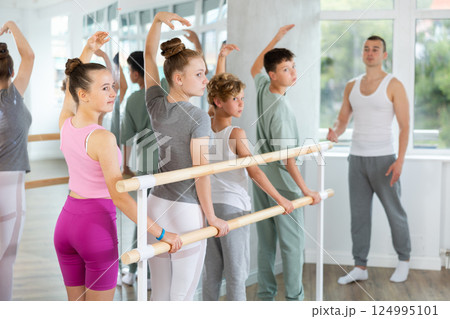 Ballet lesson for teenagers - choreographer teaches girls and boys ballet steps in studio 124995101