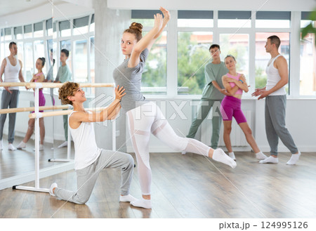 Boy and girl in pair train to perform ballet dance during rehearsal in studio Boy and girl in pair train to perform ballet dance during rehearsal in studio 124995126