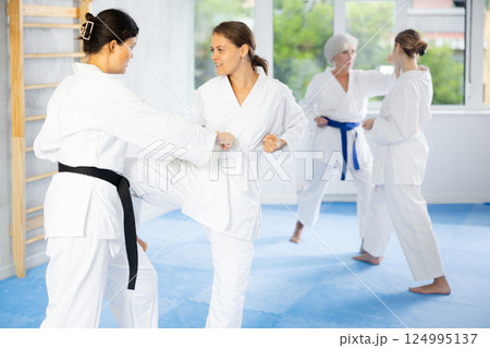 Two young women training karate techniques Two young women training karate techniques 124995137