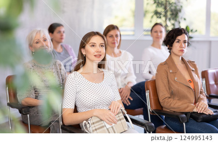 In audience, students sit staring at teacher and listen to lecture 124995143