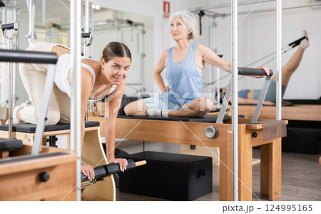 Woman pilates stretching sport in reformer bed Woman pilates stretching sport in reformer bed 124995165