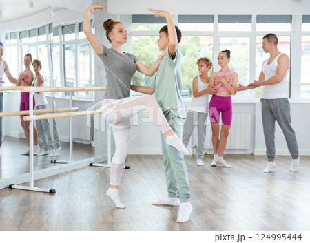 Ballet studio - teenagers girls and boys learn ballet movements in pairs Ballet studio - teenagers girls and boys learn ballet movements in pairs 124995444