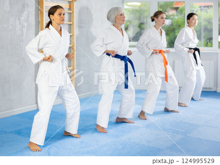 Young girl in kimono practicing punches during martial arts workout Young girl in kimono practicing punches during martial arts workout 124995529