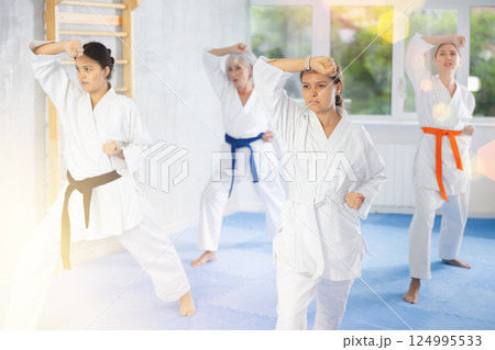 Group of women training karate techniques in studio Group of women training karate techniques in studio 124995533