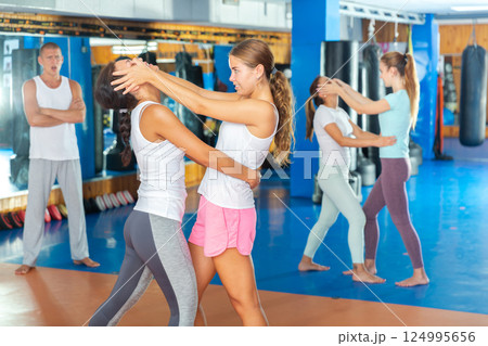 Sporty girls in pairs are training self-defence moves 124995656