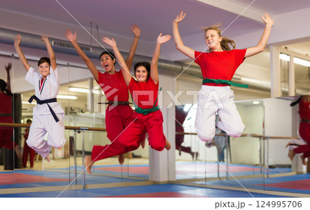 Kids and karate trainer jumping in gym Kids and karate trainer jumping in gym 124995706