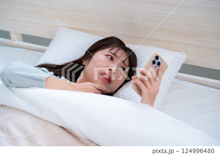 スマホを見て焦る女性 スマホを見て焦る女性 124996480