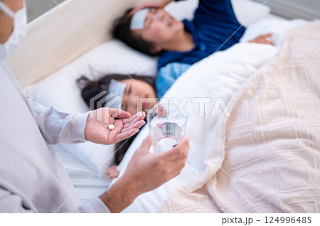 ベッドで看病される親子 124996485